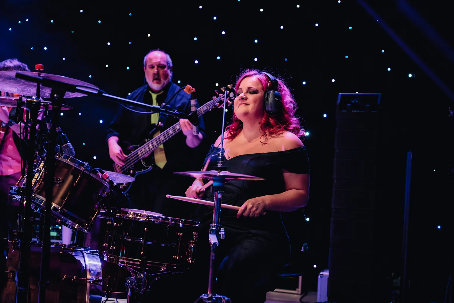 Glitz Band performing live in Aberdeen - professional drummer and bass player on stage with blue and purple lighting